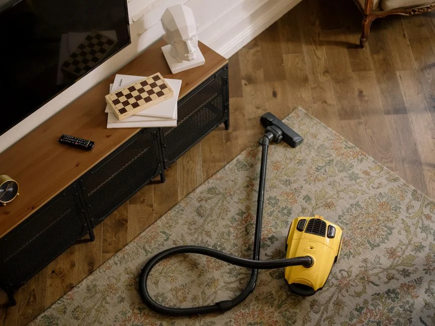 An adult man cleaning an indoor glass window, centered on household chores and keeping things clean.